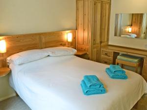 a bedroom with a white bed with blue towels on it at Morvoren - Ukc3539 in Mevagissey