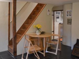 a room with a table and a staircase in a house at Blackberry Cottage in Kenton