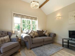 a living room with a couch and a tv at Homestead Cottage in Benniworth