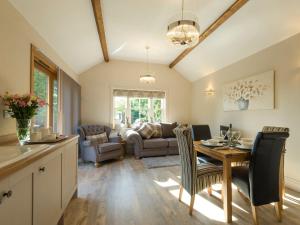 una cucina e un soggiorno con tavolo e sedie di Homestead Cottage a Benniworth