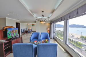 a living room with blue chairs and a large window at Saigon Quy Nhon Hotel in Quy Nhon