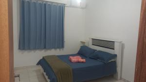 Un dormitorio con una cama con almohadas azules y una ventana en Safira Blessed, en Río de Janeiro