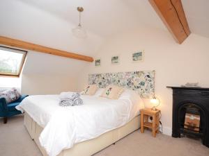 Un dormitorio con una cama y una chimenea. en Ingle Burrow, en Windermere