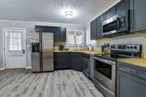 een keuken met zwarte kasten en een roestvrijstalen koelkast bij Cozy Mtn getaway. 11 miles to downtown Asheville in Asheville