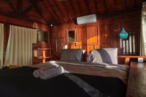 ein Schlafzimmer mit einem Bett in einem Holzzimmer in der Unterkunft The Hidden Escapes- Unique Tiny Home on Bingin Beach with Breathtaking Ocean & Sunset Views in Uluwatu + 10 Fotos