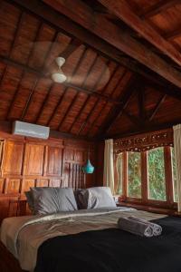 a bedroom with a large bed in a room with wooden walls at The Hidden Escapes- Unique Tiny Home on Bingin Beach with Breathtaking Ocean & Sunset Views in Uluwatu