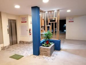 um lobby com uma coluna azul e uma planta com vasos em Departamento Familiar y bien cuidado. Wifi, piscina y jacuzzi em Tonsupa