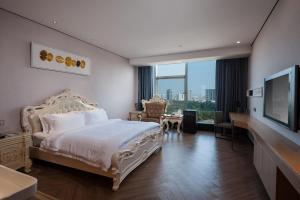 um quarto de hotel com uma cama e uma televisão de ecrã plano em Nan Yang Royal Hotel em Guangzhou