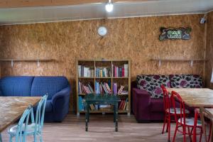 uma sala de estar com um sofá, uma mesa e cadeiras em Burriscas Campismo Rural em Montemor-o-Novo