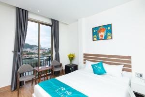 a hotel room with a bed and a balcony at BOBO Boutique Hotel in Vung Tau