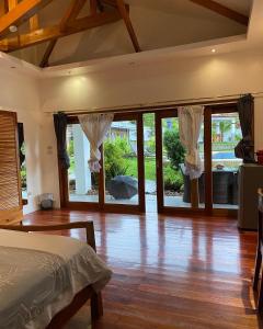sypialnia z łóżkiem i przesuwnymi szklanymi drzwiami w obiekcie Villa MountainView Guesthouse w mieście Dimiao