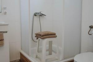 Una ducha con una pila de toallas sobre un taburete en un baño. en Burriscas Campismo Rural, en Montemor-o-Novo 13 fotos más