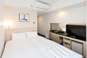 Postel nebo postele na pokoji v ubytování Sotetsu Fresa Inn Yokohama Sakuragi-cho
