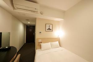Postel nebo postele na pokoji v ubytování Sotetsu Fresa Inn Yokohama Sakuragi-cho