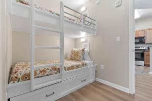 een slaapkamer met 2 stapelbedden en een keuken bij Family friendly condo in heart of Destin! Resort style pool, tennis courts minutes from beach in Destin