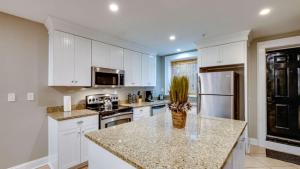 a kitchen with white cabinets and a granite counter top at 4 Bedroom Beauty Steps from the River in Savannah