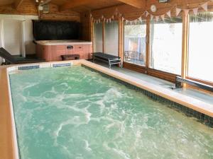 ein großer Pool mit Wasser in einem Zimmer mit Fenstern in der Unterkunft The Old Cow Shed in Barlow