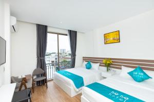 a hotel room with two beds and a balcony at BOBO Boutique Hotel in Vung Tau