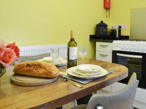 a table with a bottle of wine and a loaf of bread at The Cabin in Pevensey