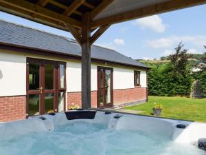 una bañera de hidromasaje en el patio trasero de una casa en River Cottage en Llangunllo