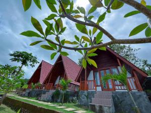 uma casa com um telhado vermelho e algumas árvores em dbelish village & resto em batumadeg