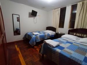um quarto de hotel com duas camas e uma televisão em hospedaje encantada em Cajamarca