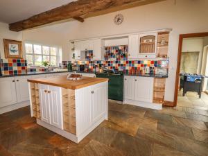 a large kitchen with white cabinets and a counter at The Barn in Ellesmere