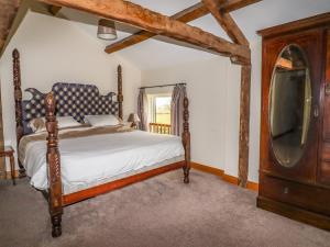 a bedroom with a bed with a dresser and a tv at The Barn in Ellesmere