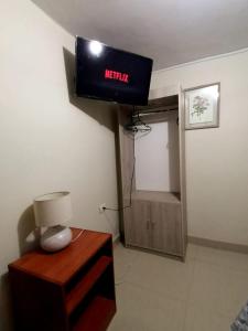 Cette chambre dispose d'une télévision et d'une table avec une lampe. dans l'établissement hospedaje encantada, à Cajamarca