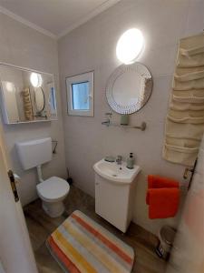 a bathroom with a white toilet and a sink at House Antonio in Miholascica (66-1) in Miholašćica