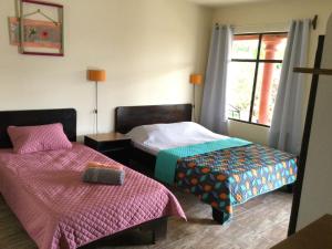 La GaritaにあるVillas el Cenizaroのベッドルーム1室(ベッド2台、窓付)