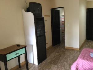 Villas el Cenizaro في La Garita: غرفة مع تلفزيون فوق خزانة الملابس