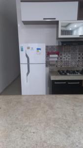 a kitchen with a white refrigerator and a stove at casa da paz in Porto Seguro