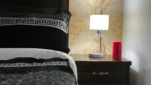 a bedroom with a bed with a lamp on a night stand at Lux Aparts Jhelum in Jhelum
