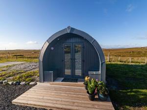 a small shed with two potted plants in front of it at Pabbay - Uk40612 in Trumisgarry