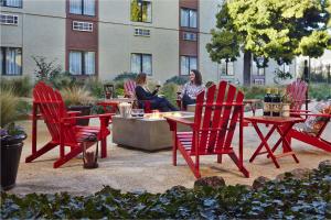 a group of red chairs and a table in a courtyard at Hotel Focus SFO in South San Francisco