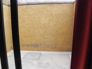a sliding glass door with a yellow wall at Apartamiento acogedor y familiar cerca Del Río in Tunuyán