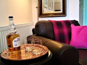 a bottle of alcohol sitting on a table with glasses at Stable Lodge in Gattonside