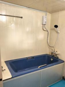 a blue tub in a room with a shower at Leaf Boat House in Miri