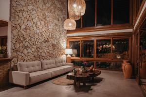 Una sala de estar con un sofá y una pared de piedra. en Aysú Trancoso Boutique Hotel, en Trancoso 68 fotos más