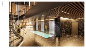 a lobby with a staircase and a pool in a building at SOHO Hotel Auckland in Auckland