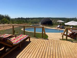 a wooden deck with chairs and a swimming pool at DOMO Y SPA INFINITO in Catillo