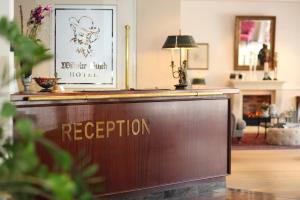 a reception desk in a living room with a hotel reception at Hotel Wilhelm Busch in Norderstedt