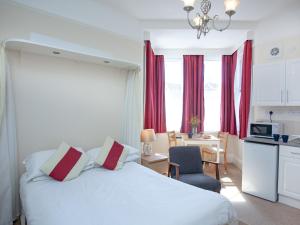 1 dormitorio con 1 cama blanca y 1 silla y cocina en Apartment Seven - Uk39843 en Paignton