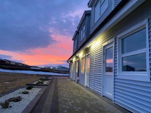 Motel Arctic Wind في Vogar: مبنى مع غروب الشمس في الخلفية