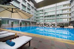 a large swimming pool in a building with a hotel at Novotel Guangzhou Baiyun Airport in Huadu
