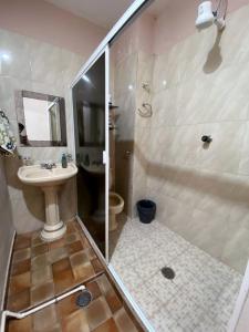 y baño con ducha y lavamanos. en Malecón Casa Grande Económica Gran Ubicación, en Mazatlán