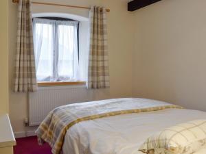 a bedroom with a bed and a window at Knowle Cottage in Colaton Raleigh