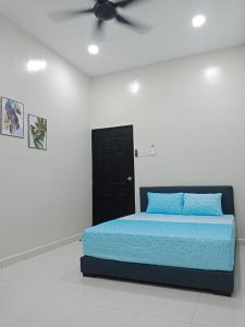 Cama en habitación blanca con ventilador de techo en 61 Homestay en Sitiawan