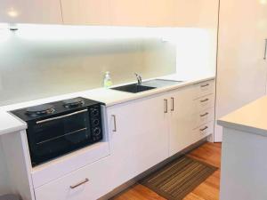 a kitchen with a sink and a stove at Beach to Bush in Stanwell Park
